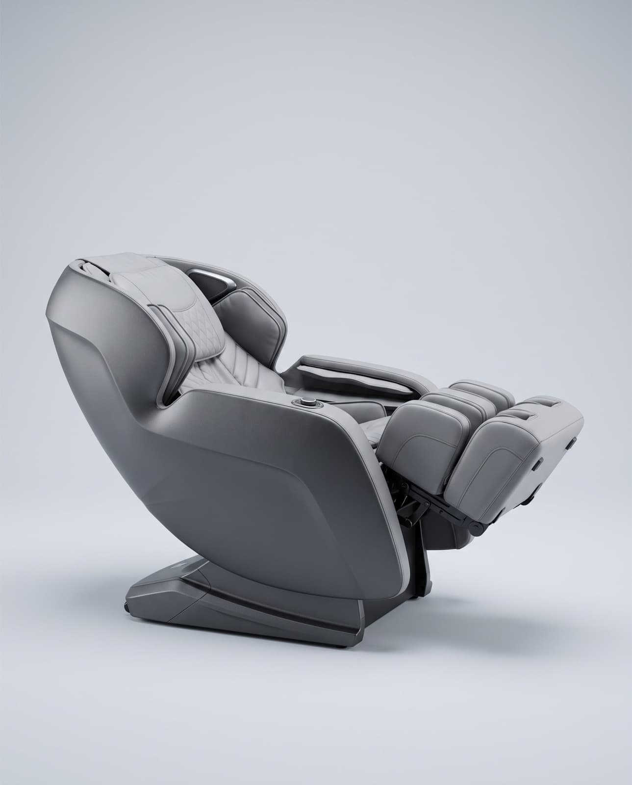 Fauteuil de massage incliné, coque graphite et garnitures gris clair, repose-jambes relevé, sur fond gris clair